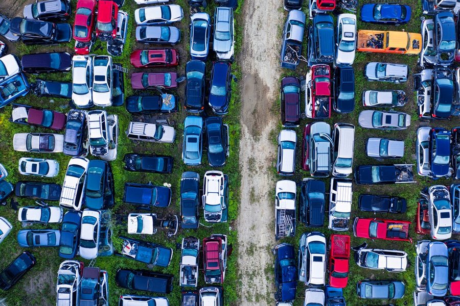 Vue en hauteur de véhicules alignés dans une casse automobile en plein air