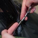 Coiffeuse coupant les cheveux d'une cliente dans un salon