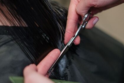 Coiffeuse coupant les cheveux d'une cliente dans un salon