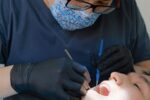 Dentiste réalisant un contrôle dentaire sur un patient à l'aide d'instruments