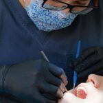 Dentiste réalisant un contrôle dentaire sur un patient à l'aide d'instruments