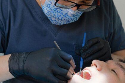 Dentiste réalisant un contrôle dentaire sur un patient à l'aide d'instruments