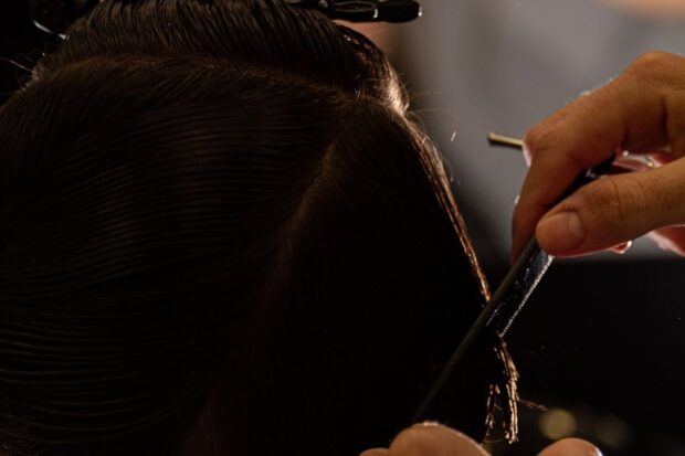 ciseaux de coiffure coupant une mèche de cheveux