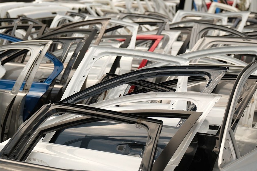 Plusieurs portières de couleurs différentes alignées dans une casse automobile