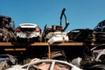 Rangées de voitures accidentées entreposées à l'air libre dans une casse automobile