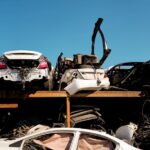 Rangées de voitures accidentées entreposées à l'air libre dans une casse automobile