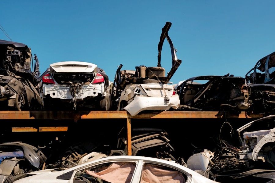 Rangées de voitures accidentées entreposées à l'air libre dans une casse automobile